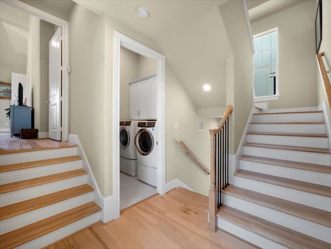Stairs with separate washer and dryer, wood finished floors, recessed lighting, baseboards, and vaulted ceiling | Image 17