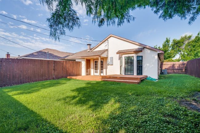 Rear view of property with french doors, stucco siding, a fenced backyard, and a deck | Image 27