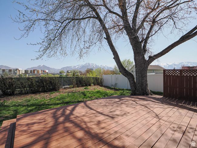 Wooden terrace featuring a fenced backyard and a mountain view | Image 19