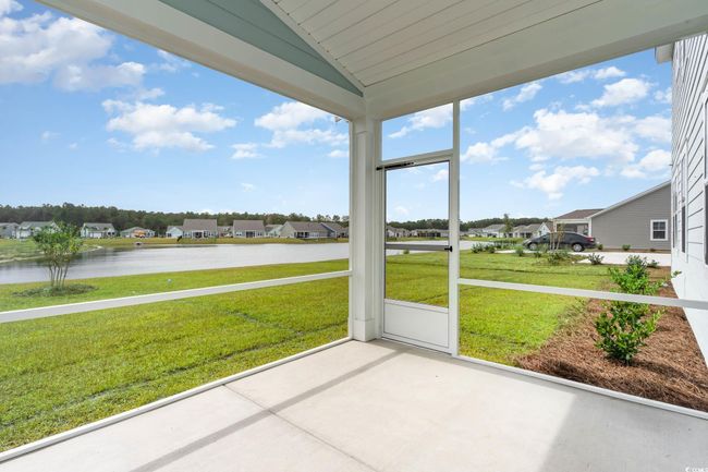 Unfurnished sunroom with vaulted ceiling, a water view, and a residential view | Image 30