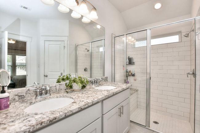 Bathroom featuring a sink, visible vents, and a stall shower | Image 24