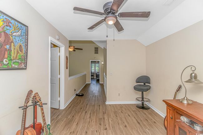 Sitting room with a ceiling fan, light wood finished floors, and lofted ceiling | Image 19