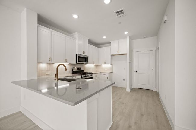 The kitchen peninsula offers a great place for a quick bite or homework station. | Image 8