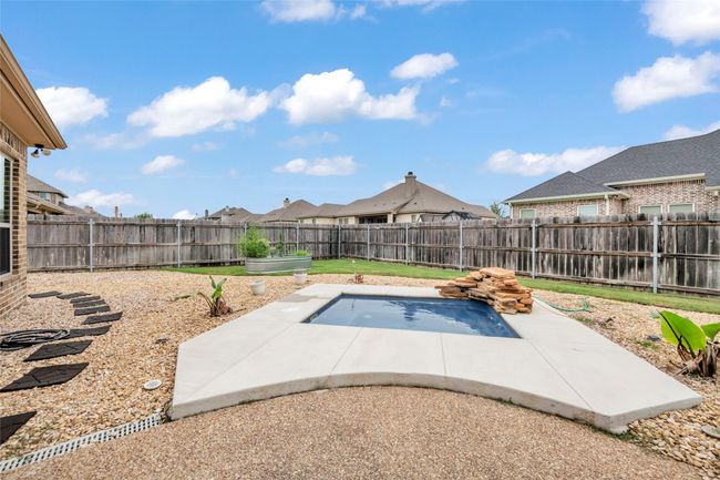 View of swimming pool with a patio and a fenced backyard | Image 6