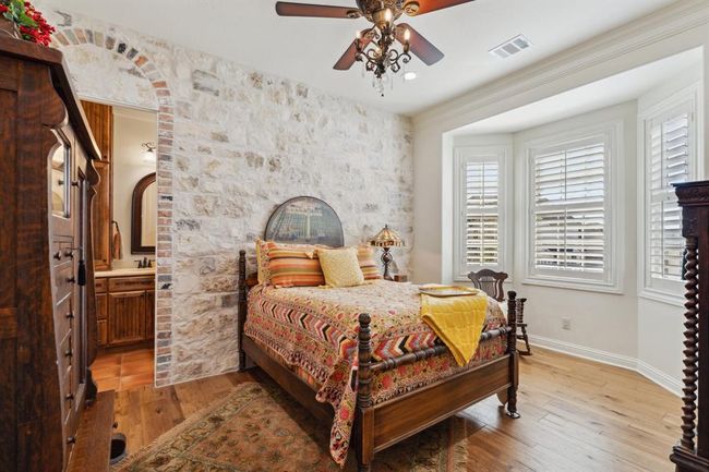 The "Tuscan" Bedroom features a quaint bay window seating area.Spectacular blended natural stone wall, accented with Old Chicago Brick faux arch at entry to ensuite bathroom. | Image 32