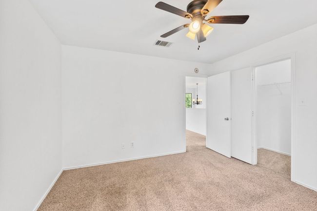 Unfurnished bedroom featuring light colored carpet, a spacious closet, and a closet | Image 27