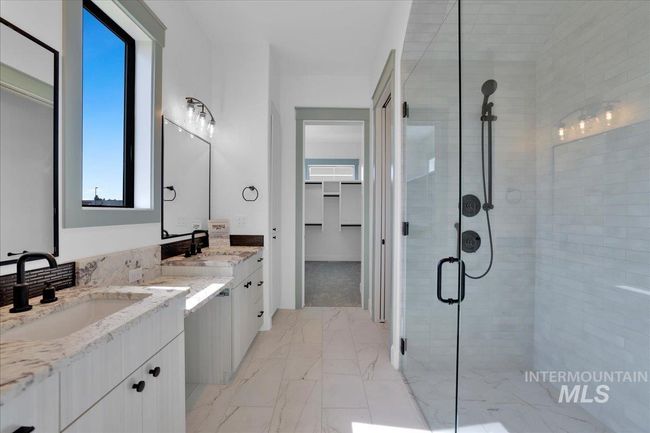 Bathroom featuring a shower stall, vanity, and marble look tiles | Image 28