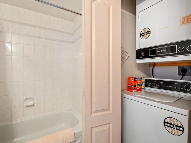 Interior space with stacked washer and dryer, water heater, and shower / bathing tub combination | Image 22