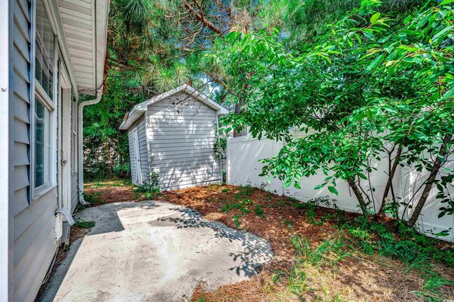 View of yard with a patio area and a storage unit | Image 34