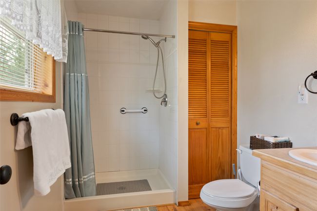 Bathroom with a closet, tiled shower, and vanity | Image 32