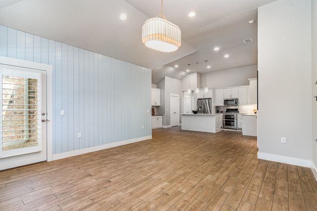 Living room featuring lofted ceiling, a chandelier, light wood-type flooring, baseboards, and recessed lighting | Image 9