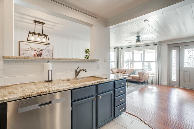 Kitchen featuring stainless steel dishwasher, a sink, healthy amount of natural light, blue cabinets, and crown molding | Image 14