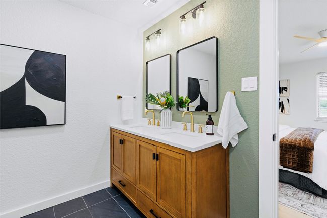 Ensuite bathroom featuring double vanity, tile patterned flooring, a ceiling fan, and a textured wall | Image 18