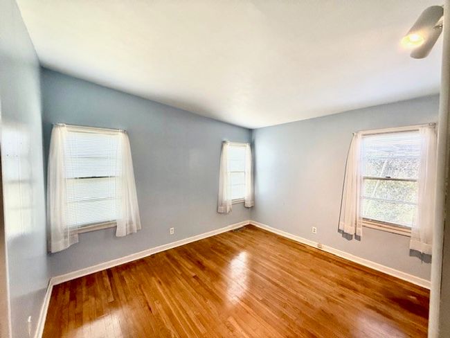 Spare room featuring baseboards and wood finished floors | Image 8