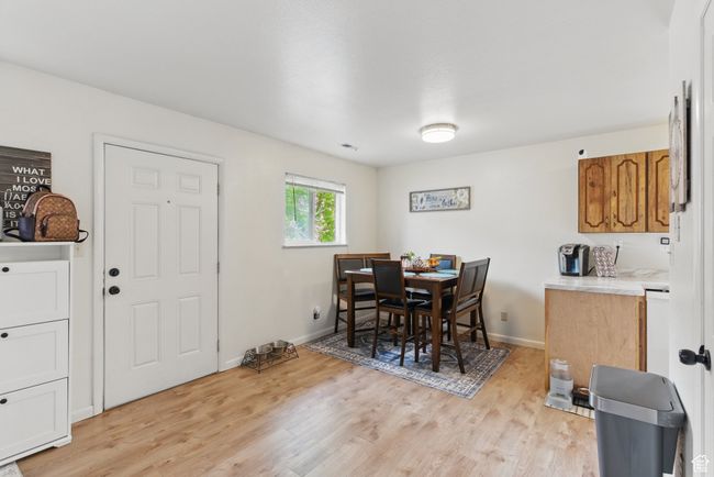 Dining room with light wood finished floors, baseboards, and visible vents | Image 23