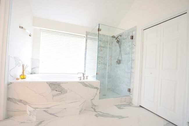 Master bathroom with a closet, a garden tub, a marble finish shower, and marble finish floors | Image 12