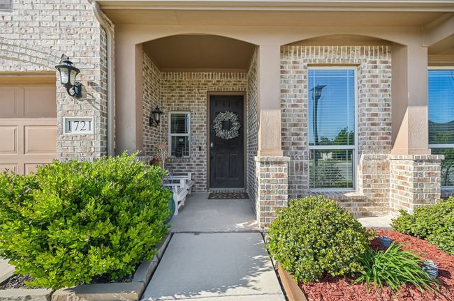 Property entrance featuring covered porch, a garage, and brick siding | Image 4