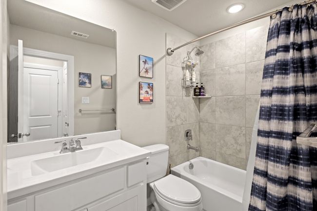 Bathroom with vanity, toilet, shower / bath combo, and visible vents | Image 18