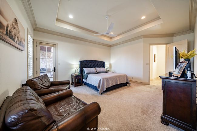 Bedroom featuring ceiling fan, a raised ceiling, light colored carpet, and crown molding | Image 21
