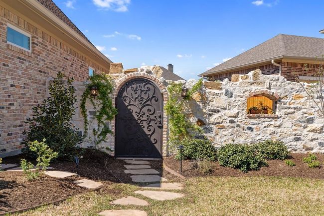 Beautiful ornate iron gate enters the garden area. | Image 44