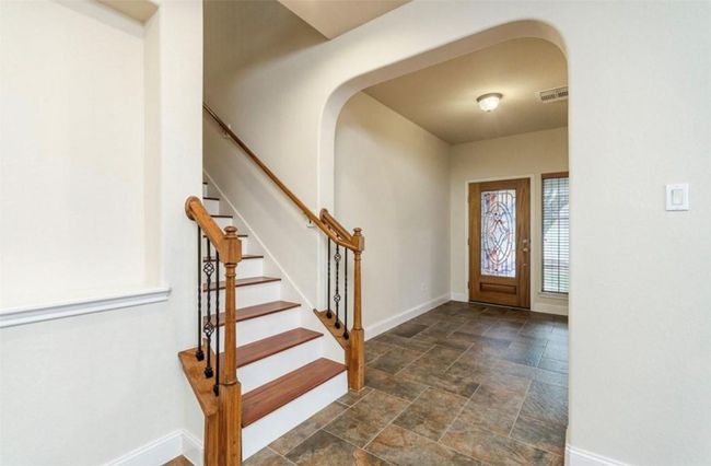 Foyer entrance featuring stone finish floors, baseboards, stairway, and arched walkways | Image 18