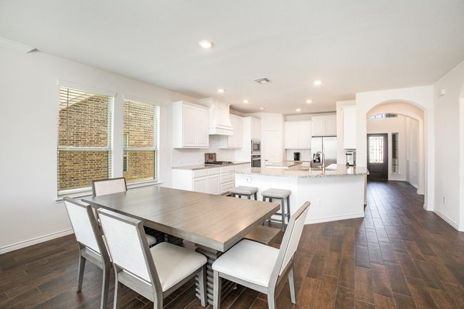 Dining area featuring baseboards, recessed lighting, dark wood-type flooring, visible vents, and arched walkways | Image 8