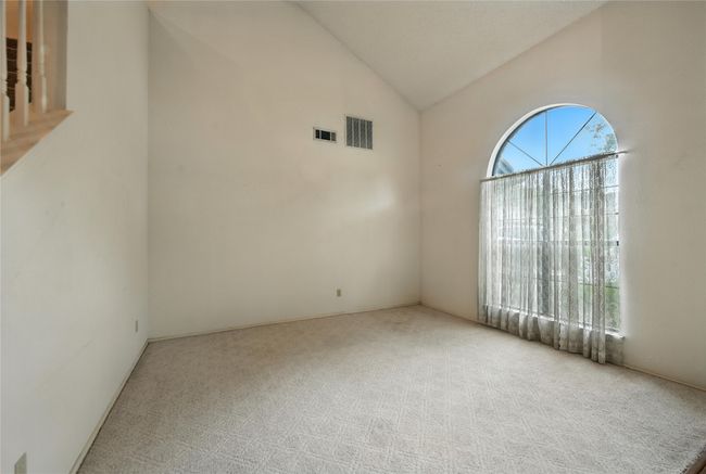 Carpeted empty room featuring lofted ceiling | Image 8