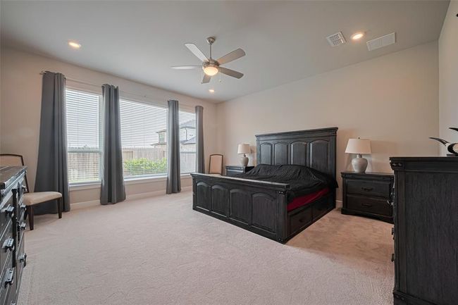 Primary bedroom is extended and private with large windows for natural light & ceiling fan. | Image 21