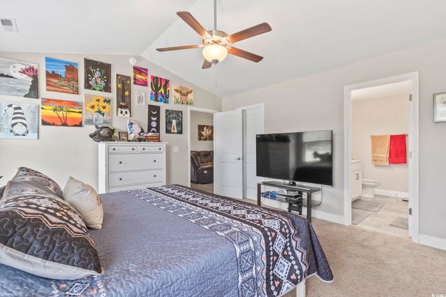 Bedroom with vaulted ceiling, carpet flooring, connected bathroom, and ceiling fan | Image 23
