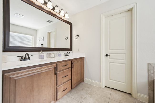 Bathroom featuring tile patterned floors, double vanity, a sink, and visible vents | Image 24