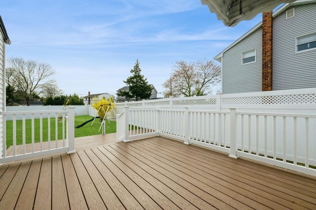 Wooden terrace featuring a fenced backyard and a lawn | Image 16