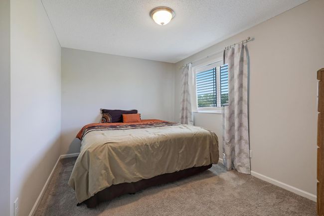 Second bedroom located on the upper level offers comfortable living space with plenty of natural light. | Image 22