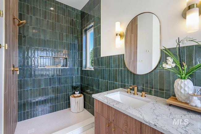 Bathroom featuring tile walls, vanity, and a walk in shower | Image 24
