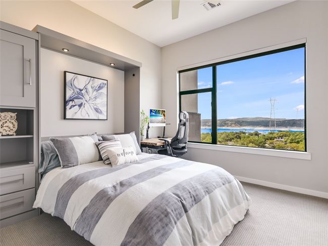 Another guest bedroom features an upgraded ceiling fan, an auto-powered roller window shade and large window offering gorgeous Lake Travis views. | Image 22