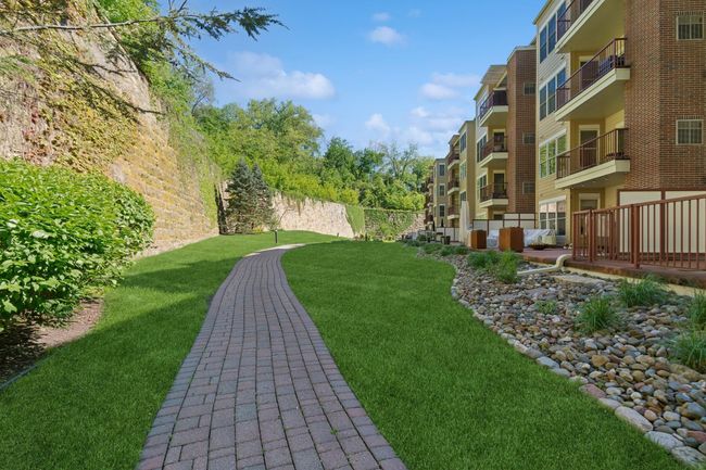 Paver sidewalks, lush vegetation and mature trees, river rock landscaping, and the iconic limestone wall beautifully capture the essence of Stillwater’s charm and character! | Image 12