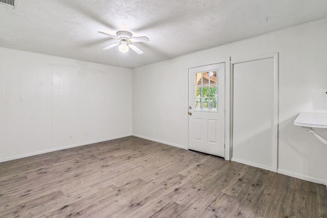 Empty room featuring a ceiling fan, wood finished floors, and a textured ceiling | Image 19