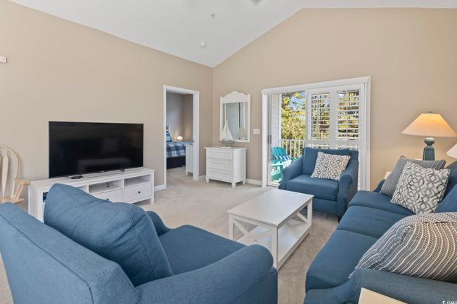 Carpeted living room with high vaulted ceiling and baseboards | Image 13