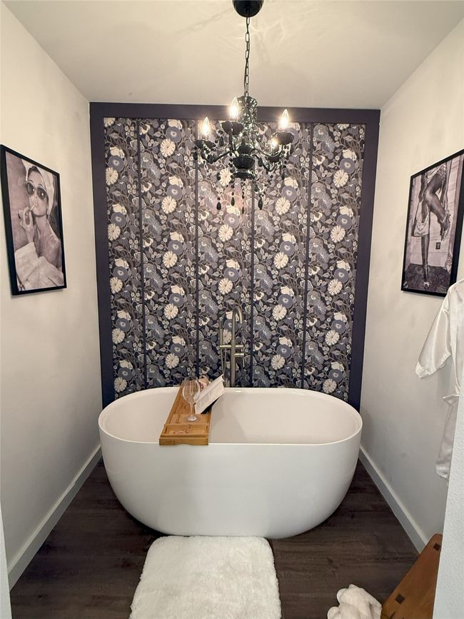 Bathroom with a chandelier, wood finished floors, and a soaking tub | Image 24