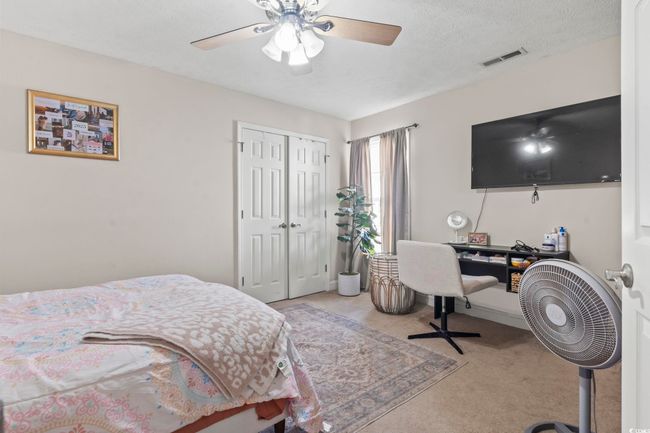 Bedroom with light colored carpet, a closet, and a ceiling fan | Image 23