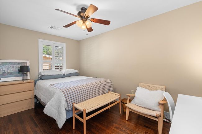 Bedroom featuring dark wood-style flooring, visible vents, and a ceiling fan | Image 21