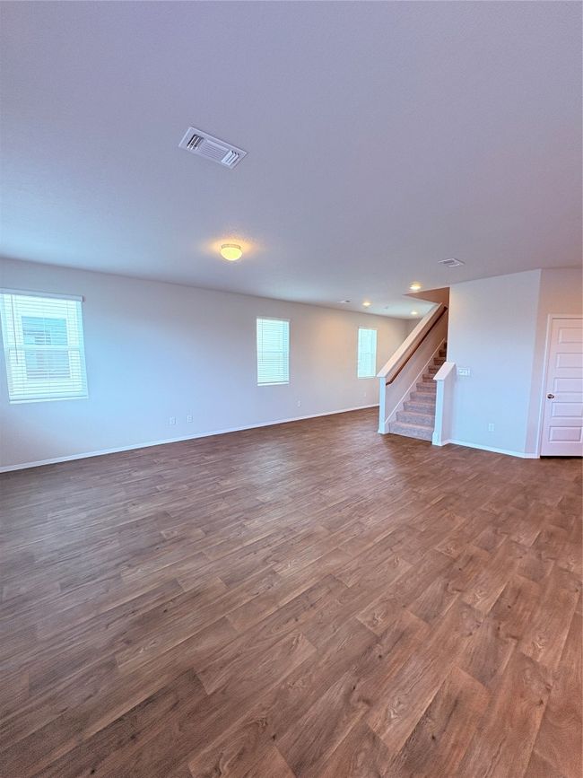 Below grade area with stairs, dark wood finished floors, baseboards, visible vents, and recessed lighting | Image 5