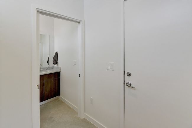 Hallway with concrete floors, a sink, and baseboards | Image 25