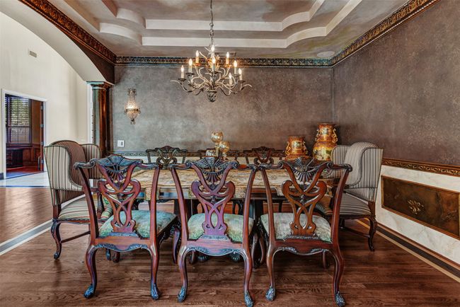 Step straight into a castle dining room! The double tray ceiling, ornate chandelier and subdued faux wall painting will transport you to the continent! | Image 9