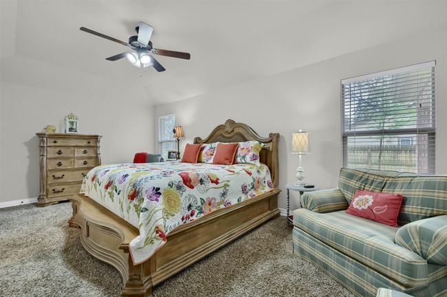 Carpeted bedroom with a ceiling fan, baseboards, and vaulted ceiling | Image 17