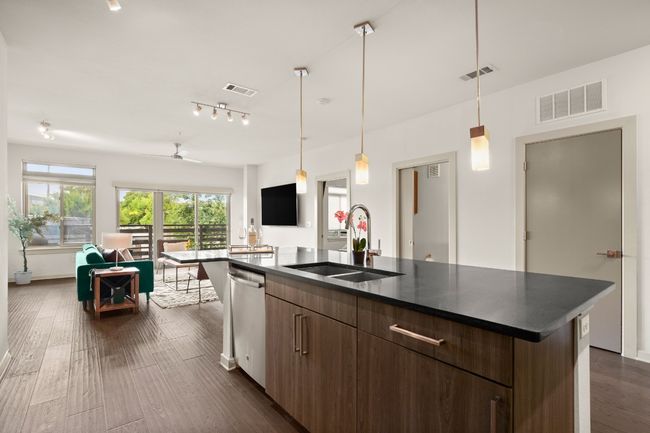 Kitchen featuring a sink, dishwasher, open floor plan, dark countertops, and dark wood-style flooring | Image 27