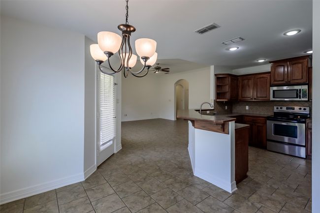 Kitchen with open shelves, visible vents, arched walkways, and appliances with stainless steel finishes | Image 21