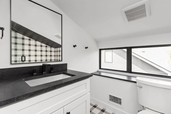 Bathroom with vanity and lofted ceiling | Image 32
