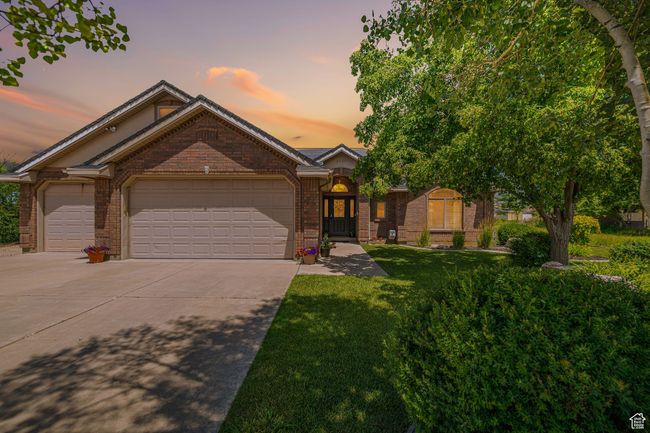 View of front facade with concrete driveway, brick siding, an attached garage, and a front yard | Image 35