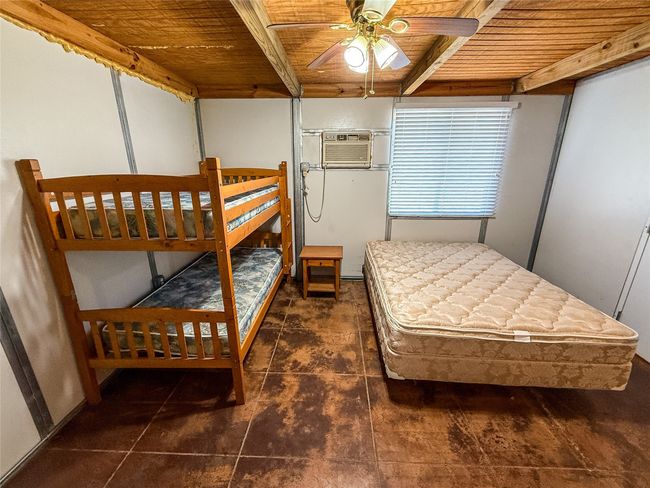 Bedroom with beamed ceiling, a wall mounted air conditioner, and wood ceiling | Image 20