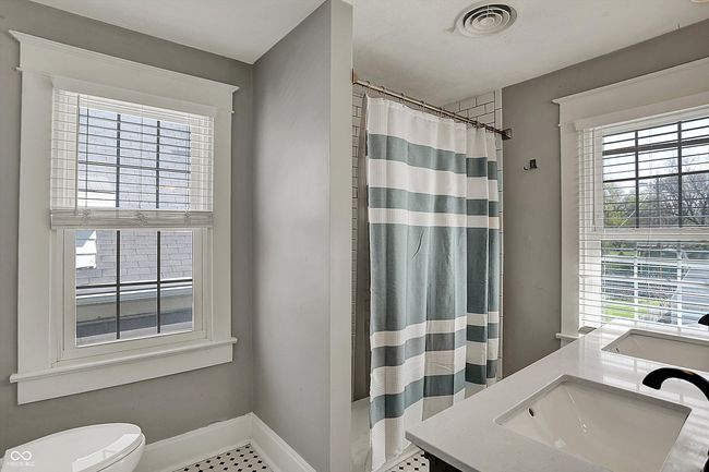 full bathroom featuring toilet, baseboards, visible vents, a shower with shower curtain, and vanity | Image 31
